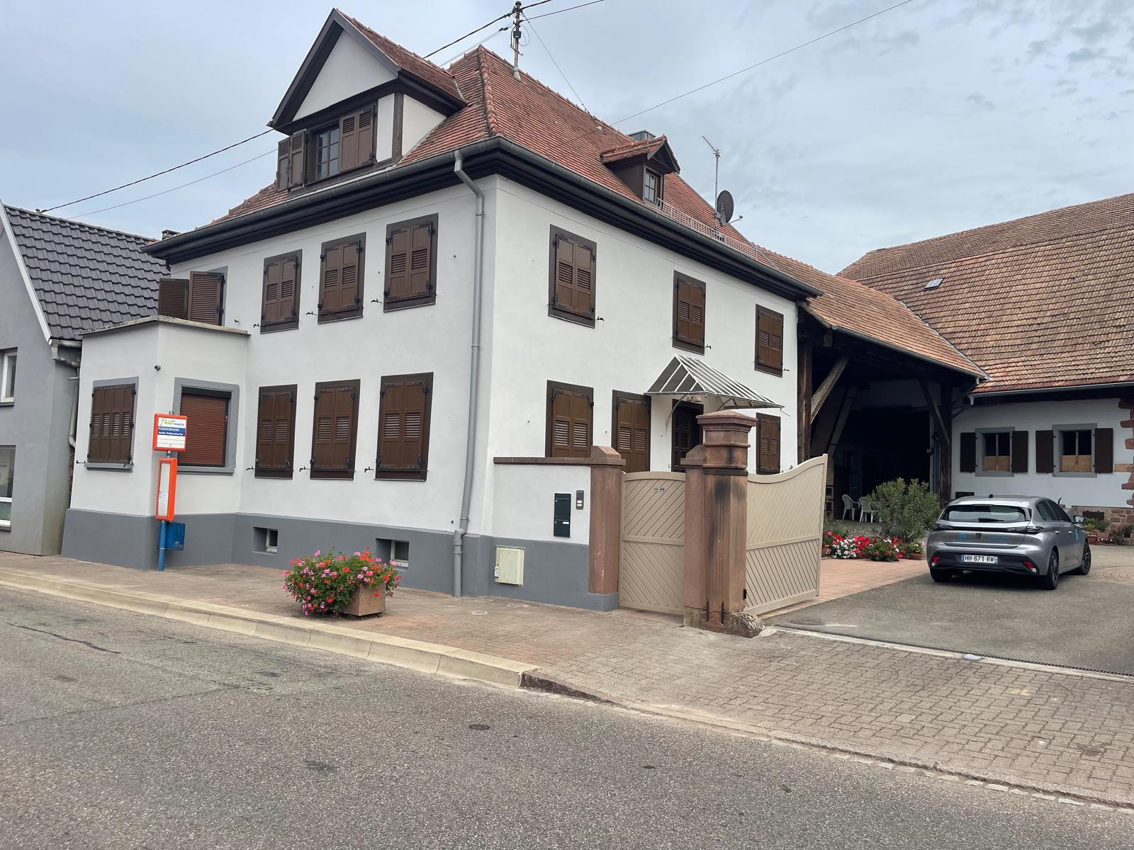 Façadier Crépi Centre remettant un devis de ravalement à un propriétaire devant une maison en Alsace