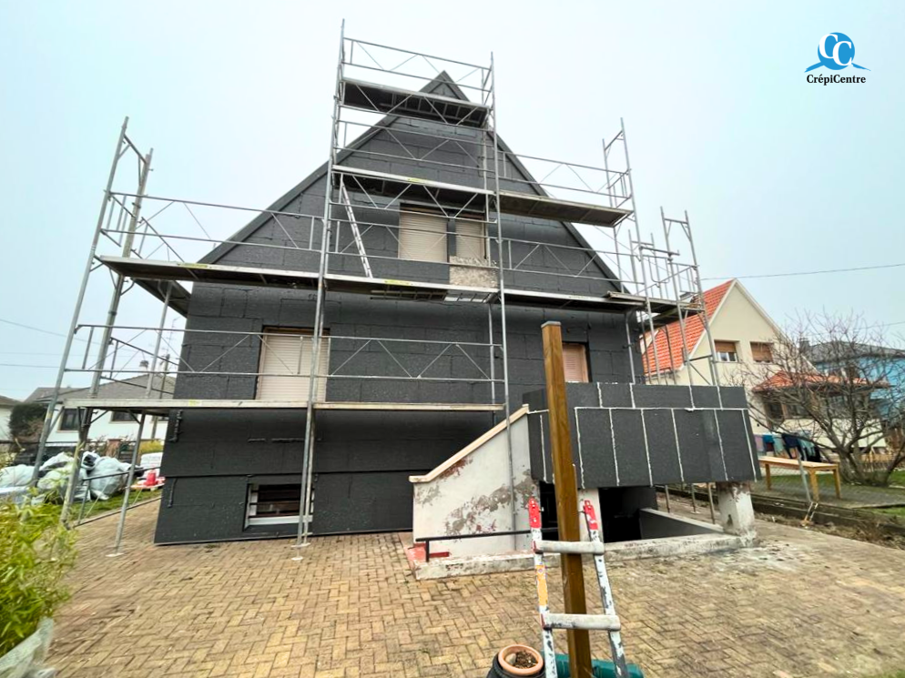 Chantier d'isolation par l'extérieur avec panneaux isolants posés sur la façade