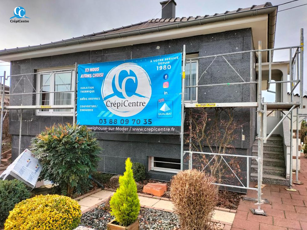 Chantier d'isolation des murs par l'extérieur (ITE) sur une maison, panneaux isolants et enduit en cours de pose